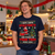 I Hope Santa Steals Your TV Funny Christmas T-Shirt — man wearing the navy tee at a Christmas house party