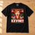 Black KEVIN!!! Catherine O’Hara Christmas T-Shirt flat lay on an oak workbench