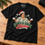 Let It Snow Christmas T-shirt laid flat on an oak workbench