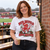 Red Devils Merry Christmas Football T-Shirt — woman wearing the white tee at a football ground