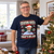 Model wearing the Navy Roy Keane That’s His Job Christmas T-Shirt beside a Christmas tree